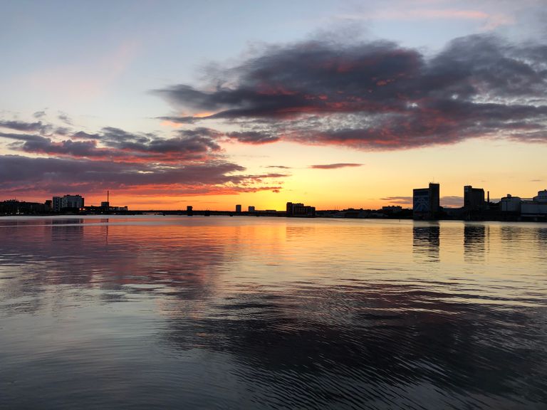 Captivating sunset with city skyline reflection on water in Aalborg, Denmark - The Essential Cruise Shop Blog Port Guide
